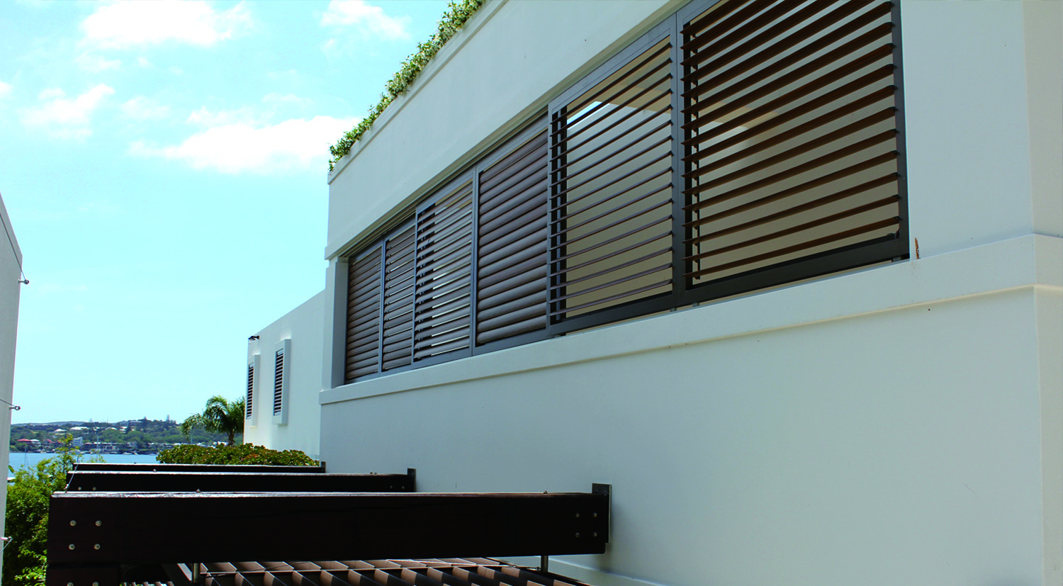 Horizontal INNOWOOD composite louvres on a white rendered residential facade